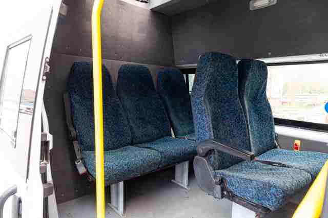 Five seats of a utility car in the back of a van with a partition dividing the salon into two parts, carpeted with a window and a hatch. Additional equipment of vehicles